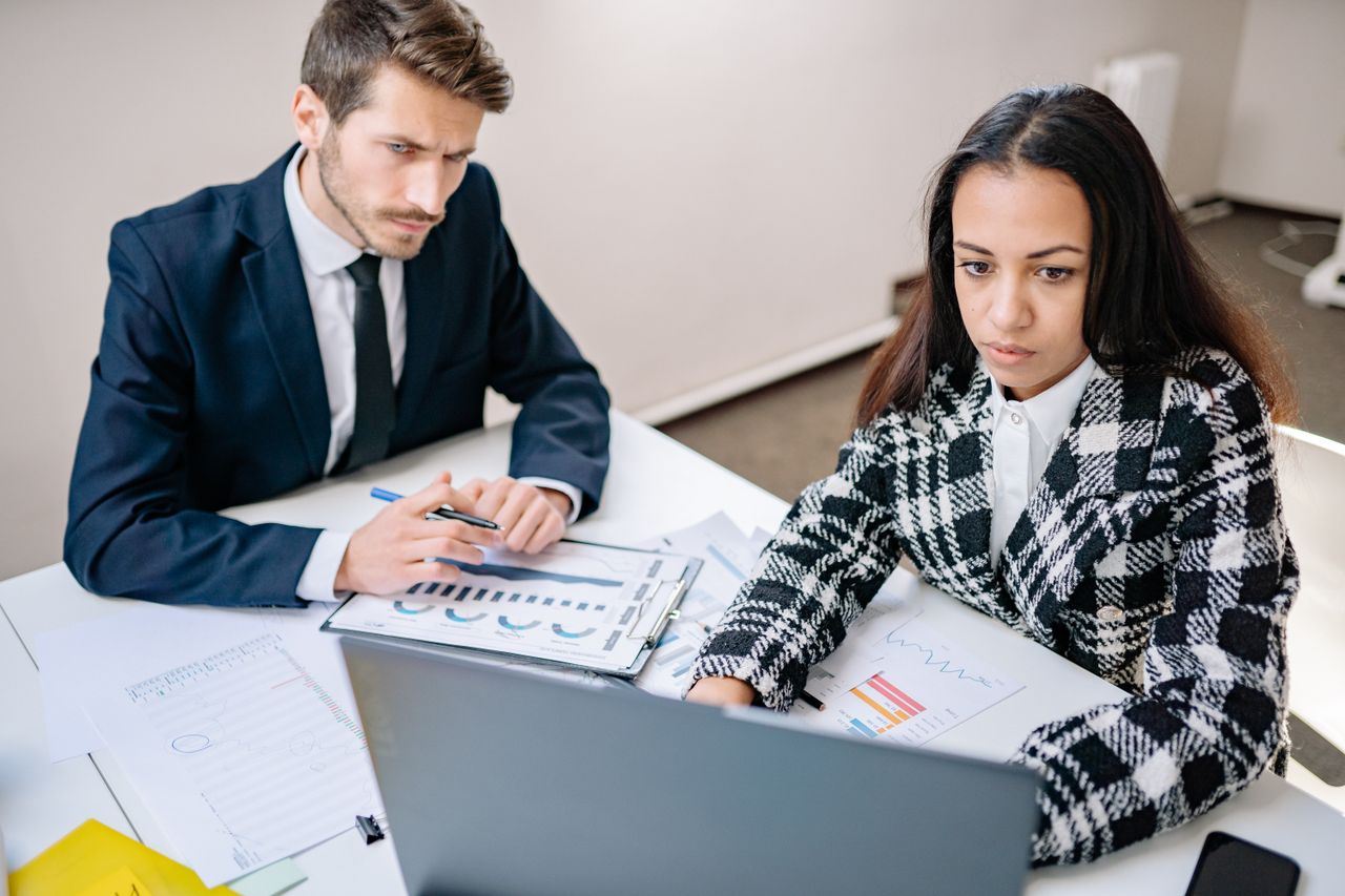 Colleagues reviewing a list of customer contacts on a laptop