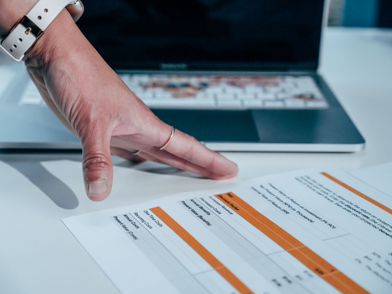 A person reviewing a sales dashboard with charts on a laptop
